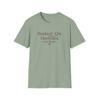 Sage green Comfort Colors t-shirt with "Hooked On Horizons." and "REEL ESHN" text, featuring a fishing lure and hook graphic.