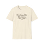 Unisex Comfort Colors cream t-shirt with "Hooked On Horizons" and a fishing hook graphic in brown.