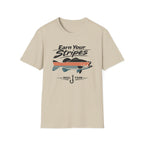 Unisex Comfort Colors sand t-shirt with "Earn Your Stripes" text, striped bass graphic, and fishing hook.