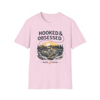 Pink unisex Comfort Colors tee with "HOOKED & OBSESSED" and a fishing reel graphic.