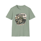Sage green Comfort Colors t-shirt with a "Hooked For Life" fishing skull graphic.
