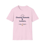 Pink Comfort Colors unisex tee with "Chasing Sunsets & Lunkers" and "REEL FSHN" fishing hook graphic.