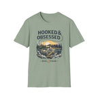 Unisex sage green cotton tee with "Hooked & Obsessed" text and a fishing reel graphic.
