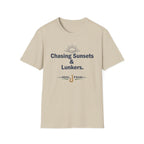 Comfort Colors sand t-shirt with "Chasing Sunsets & Lunkers" text, sun graphic, and fishing hook.