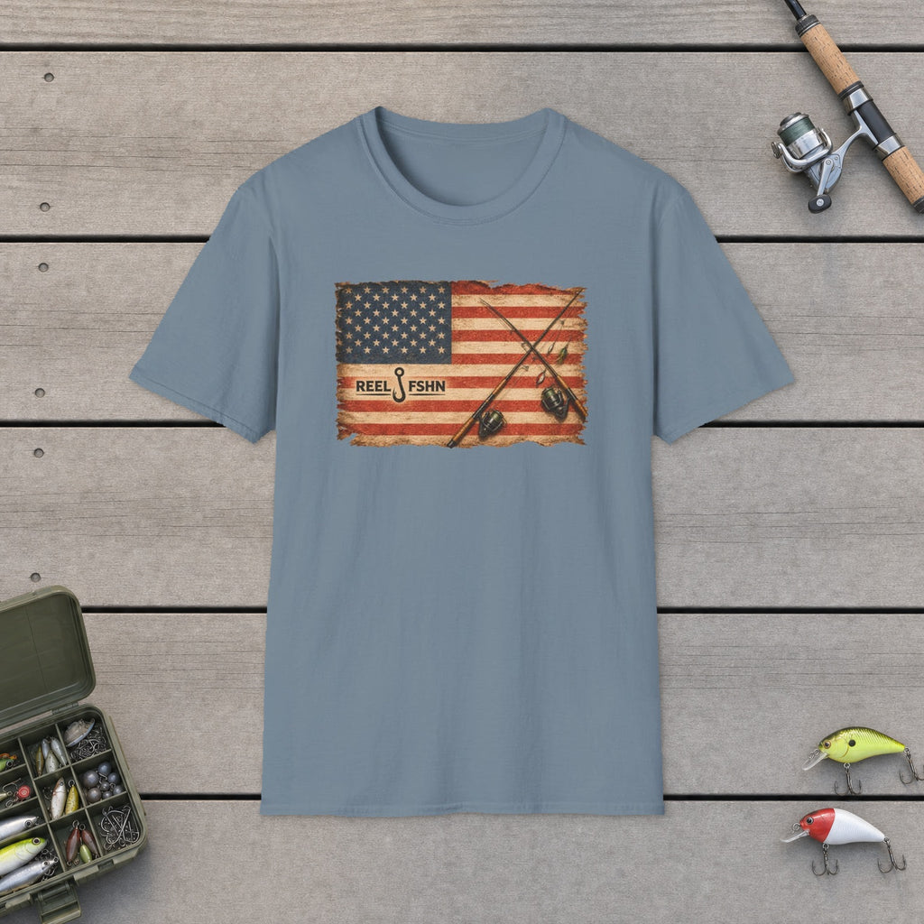 American Flag With Two Rods T-Shirt flat-laid on wooden dock boards beside a fishing rod and tackle box