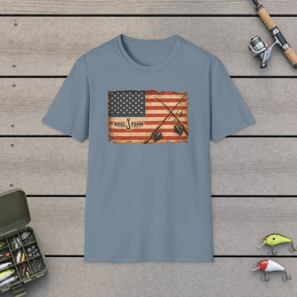 American Flag With Two Rods T-Shirt on a wooden dock with fishing rod, reel, tackle box and lures