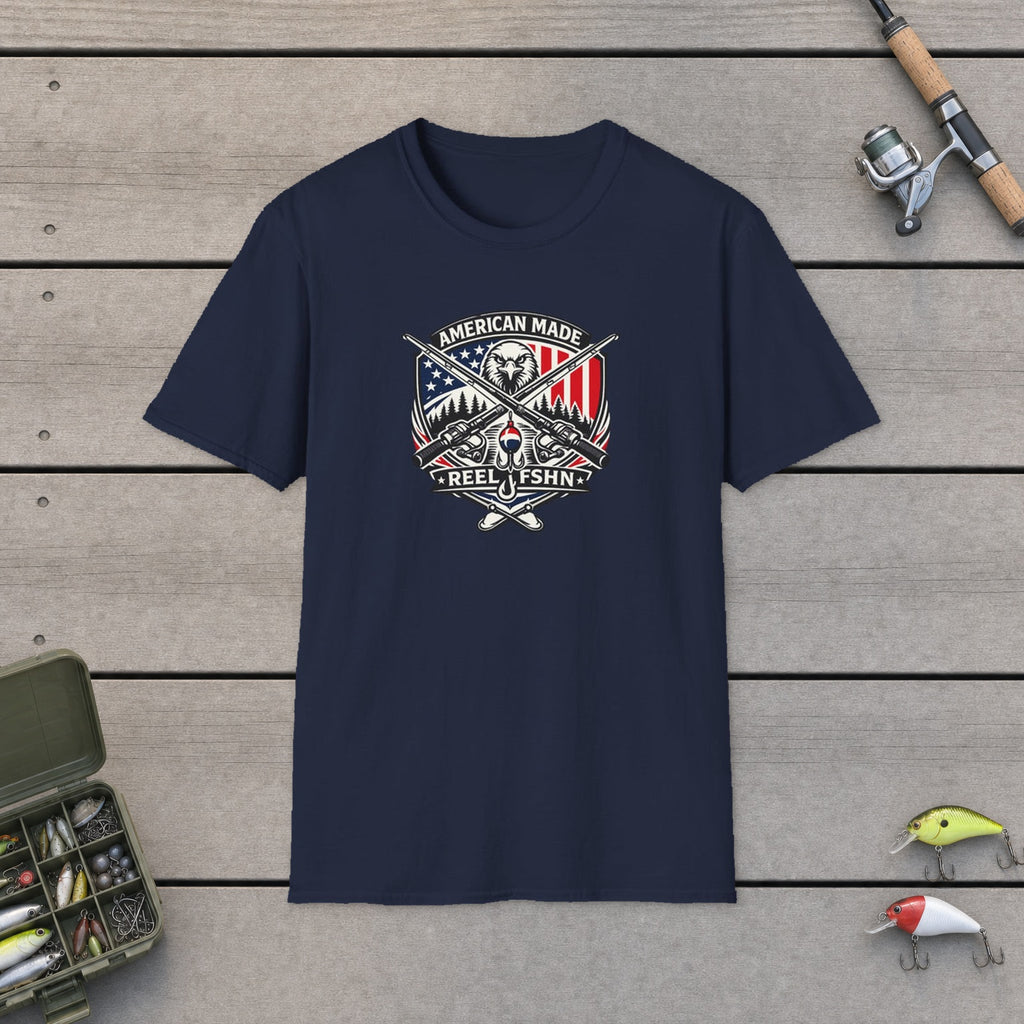 American Made T-Shirt flat-laid on wooden dock boards beside a fishing rod and tackle box
