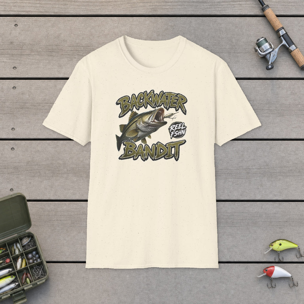 Backwater Bandit T-Shirt on a wooden dock with fishing rod, reel, tackle box and lures