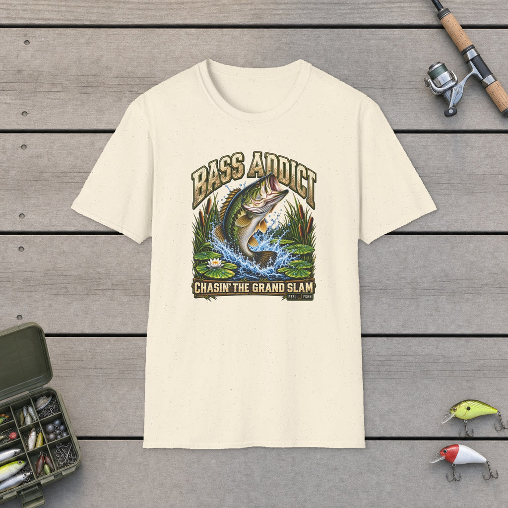 Bass Addict T-Shirt flat-laid on wooden dock boards beside a fishing rod and tackle box