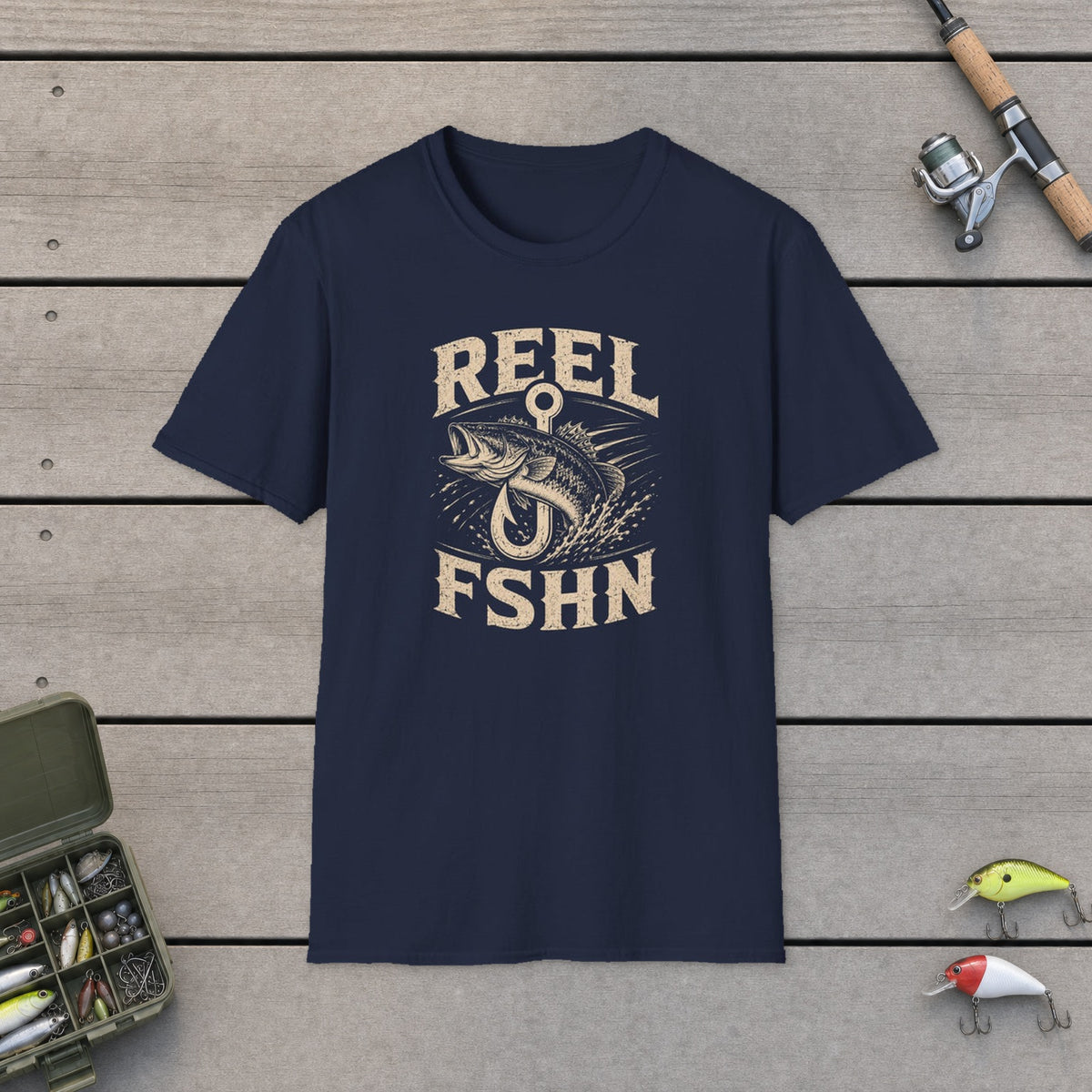 Bass Through Hook T-Shirt on a wooden dock with fishing rod, reel, tackle box and lures