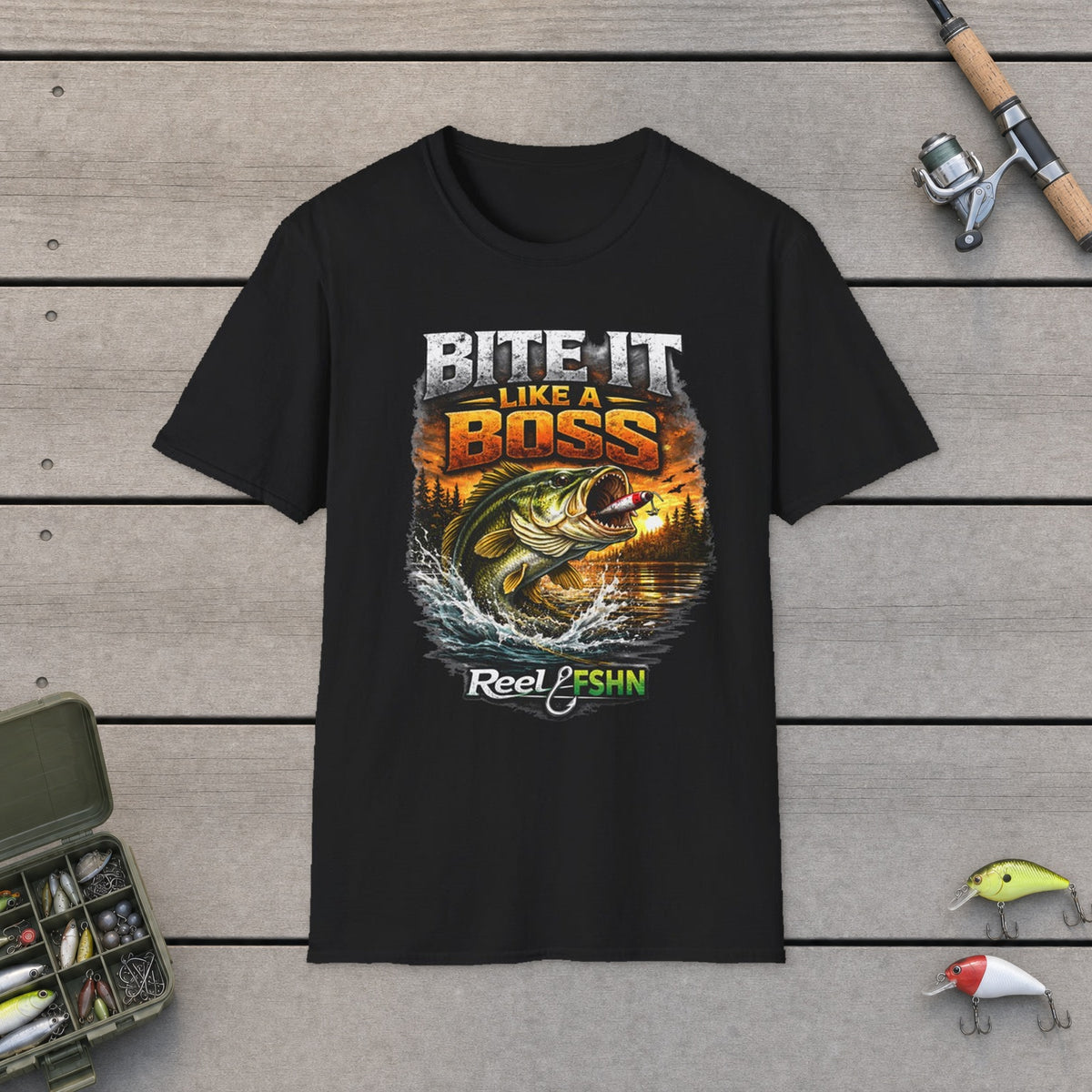 Bite It Like A Boss T-Shirt on a wooden dock with fishing rod, reel, tackle box and lures