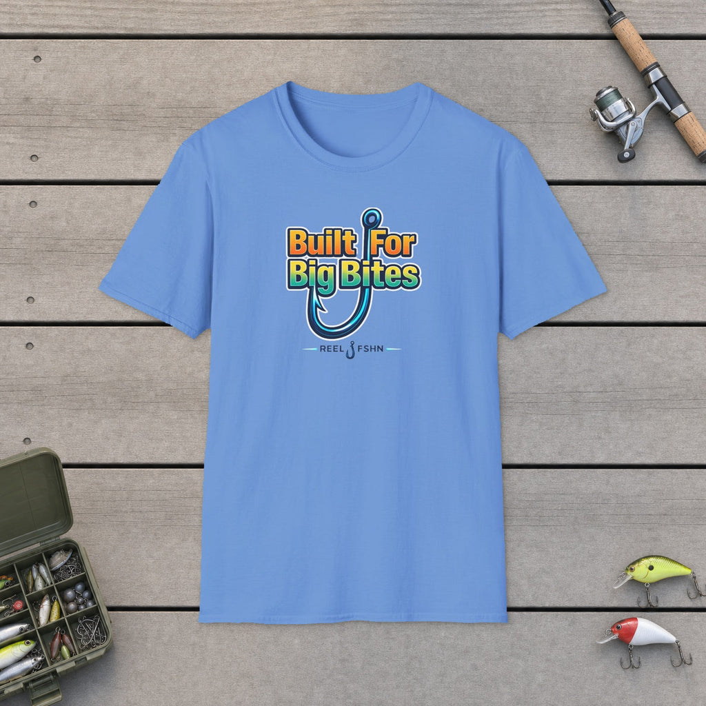 Built For Big Bites T-Shirt flat-laid on wooden dock boards beside a fishing rod and tackle box