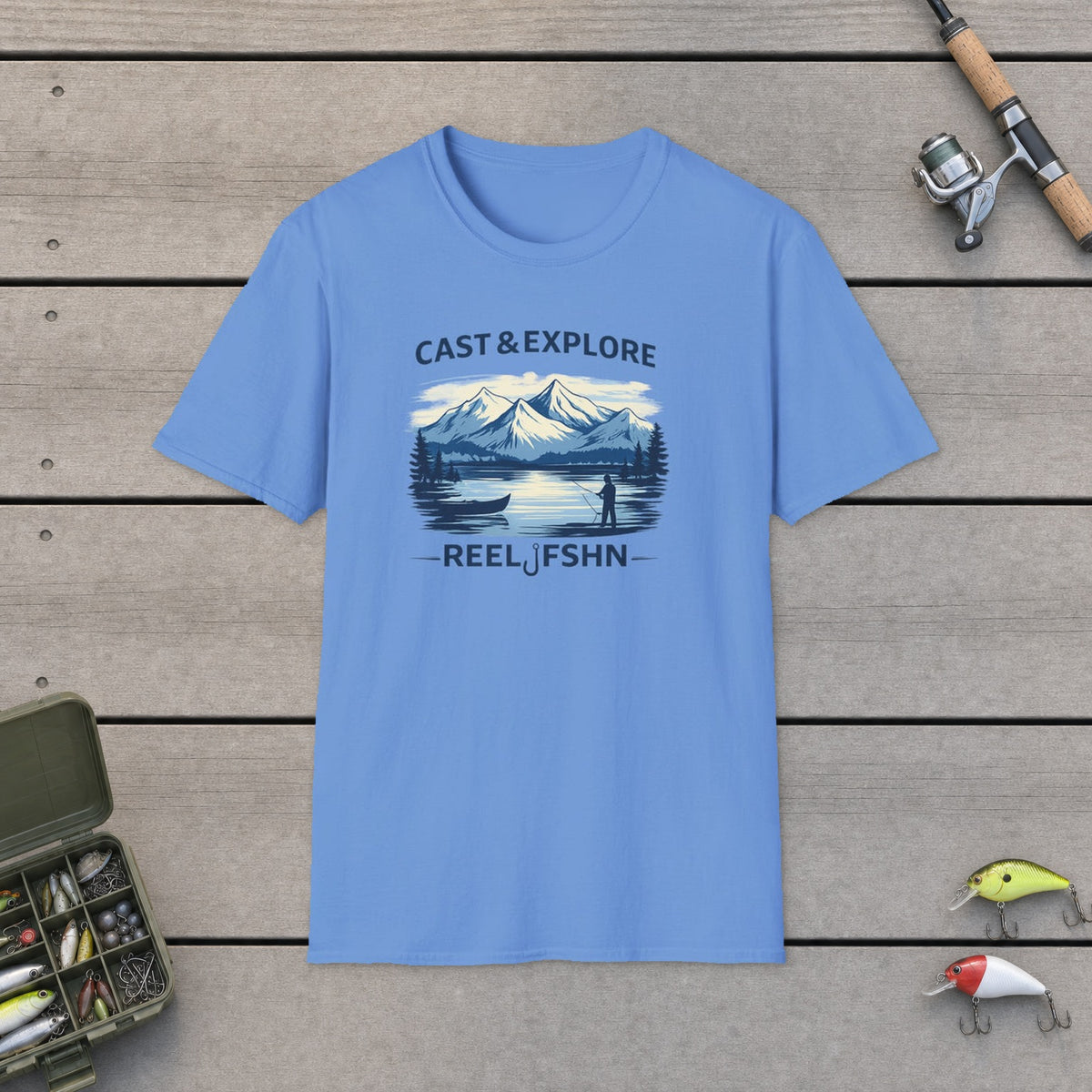 Cast & Explore  T-Shirt on a wooden dock with fishing rod, reel, tackle box and lures