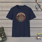 Claim The Water T-Shirt on a wooden dock with fishing rod, reel, tackle box and lures