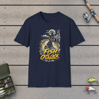 Fish O'Clock T-Shirt on a wooden dock with fishing rod, reel, tackle box and lures