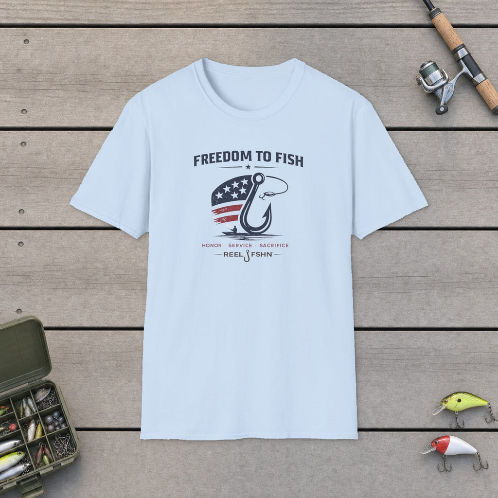 Freedom To Fish T-Shirt flat-laid on wooden dock boards beside a fishing rod and tackle box