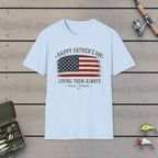 Happy Father's Day Loving Them Always T-Shirt on a wooden dock with fishing rod, reel, tackle box and lures