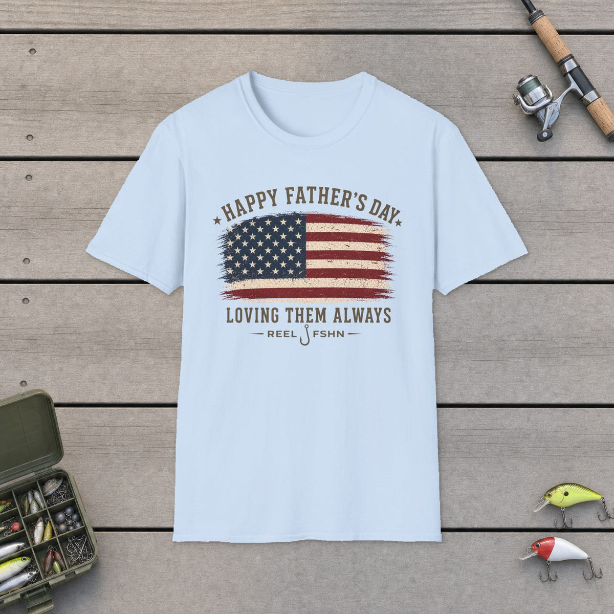 Happy Father's Day Loving Them Always T-Shirt on a wooden dock with fishing rod, reel, tackle box and lures