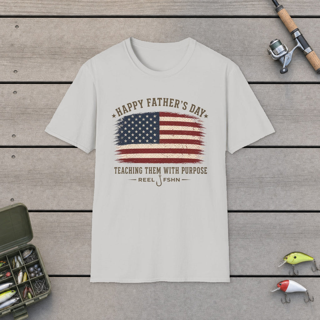 Happy Father's Day Teaching Them With Purpose T-Shirt flat-laid on wooden dock boards beside a fishing rod and tackle box