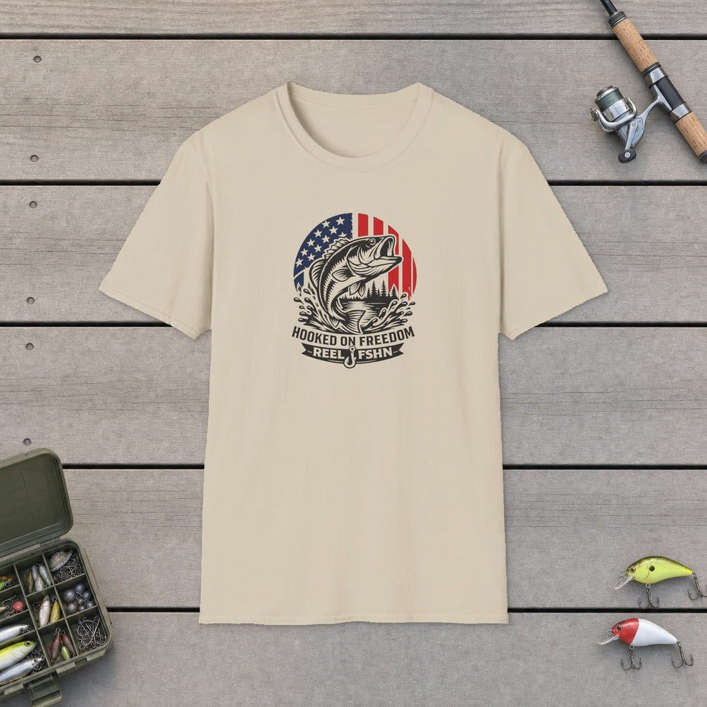 Hooked On Freedom T-Shirt flat-laid on wooden dock boards beside a fishing rod and tackle box