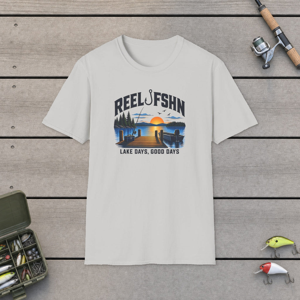 Lake Days Good Days T-Shirt flat-laid on wooden dock boards beside a fishing rod and tackle box