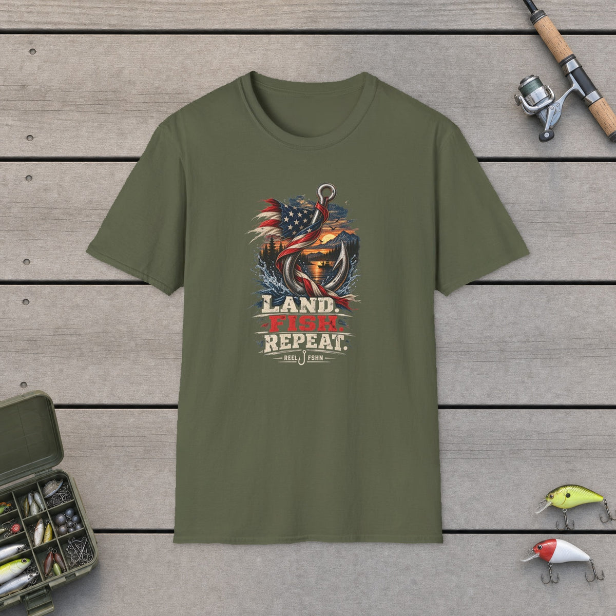 Land. Fish. Repeat. T-Shirt on a wooden dock with fishing rod, reel, tackle box and lures