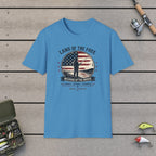 Land Of The Free Because Of The Brave T-Shirt on a wooden dock with fishing rod, reel, tackle box and lures