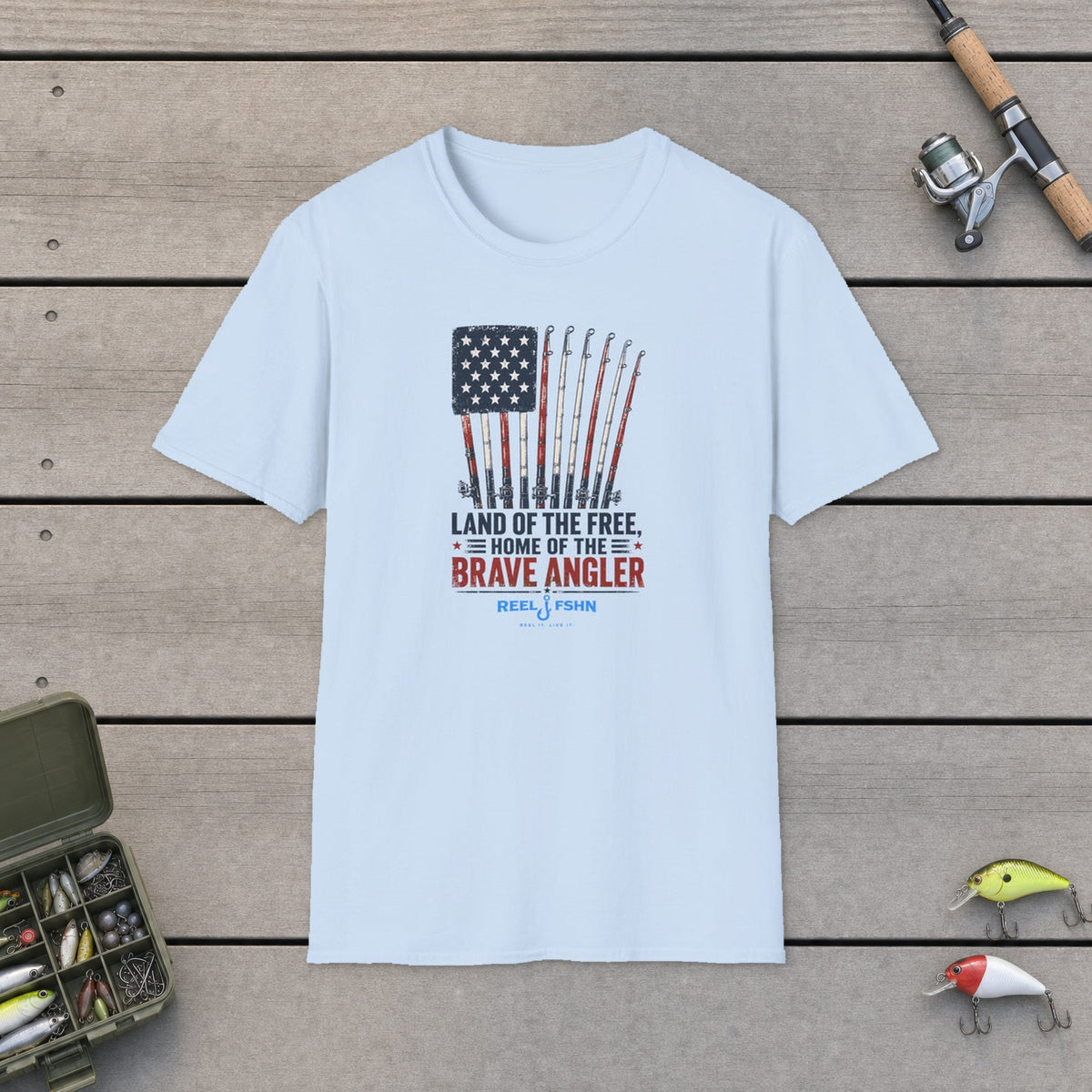 Land Of The Free Home Of The Brave Angler T-Shirt on a wooden dock with fishing rod, reel, tackle box and lures