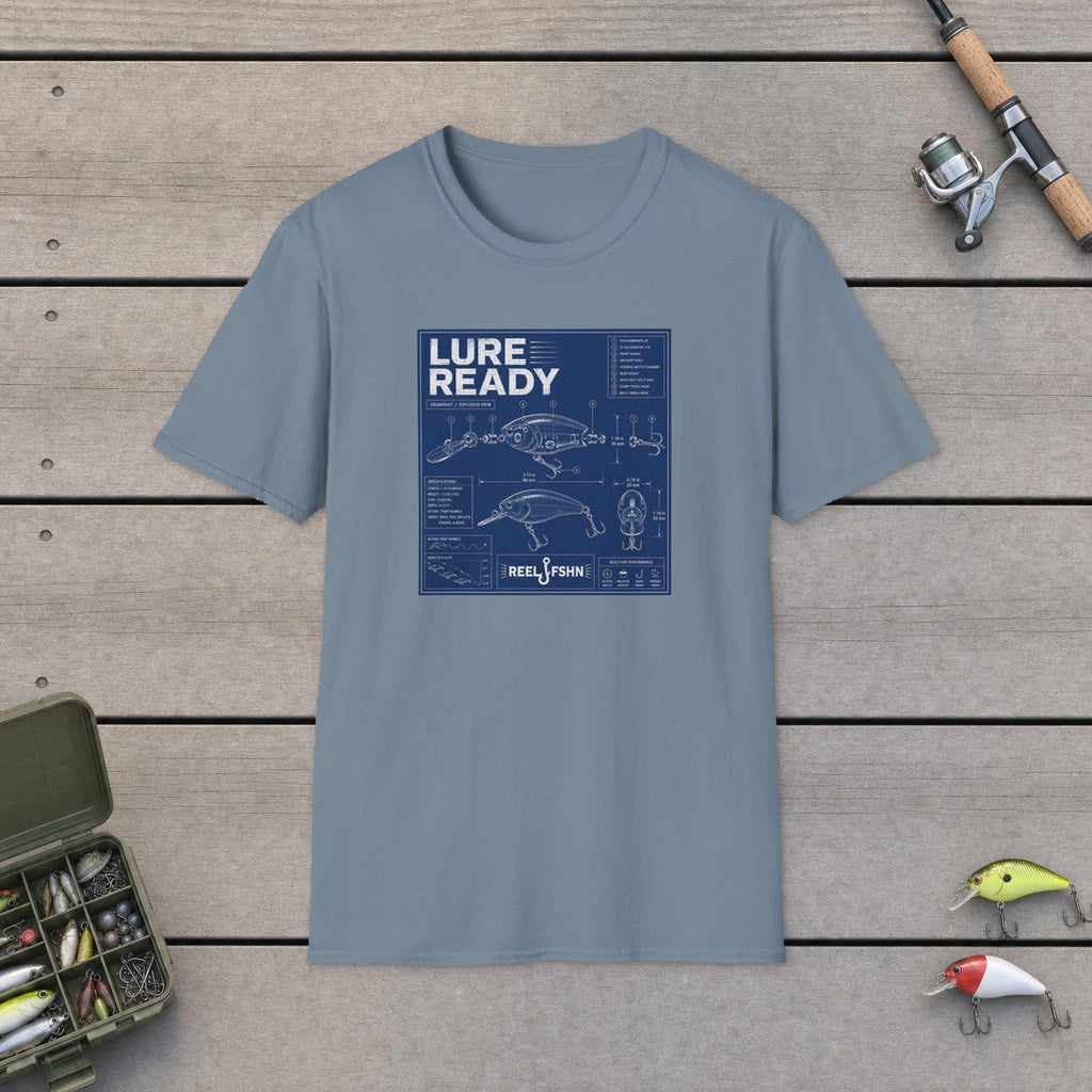Lure Ready Blue Print  T-Shirt flat-laid on wooden dock boards beside a fishing rod and tackle box