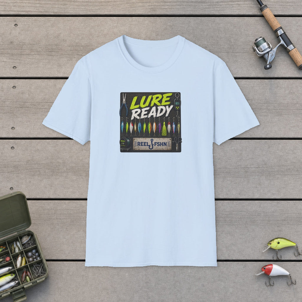 Lure Ready Peg Board  T-Shirt flat-laid on wooden dock boards beside a fishing rod and tackle box