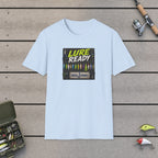 Lure Ready Peg Board  T-Shirt on a wooden dock with fishing rod, reel, tackle box and lures