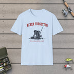 Never Forgotten T-Shirt on a wooden dock with fishing rod, reel, tackle box and lures