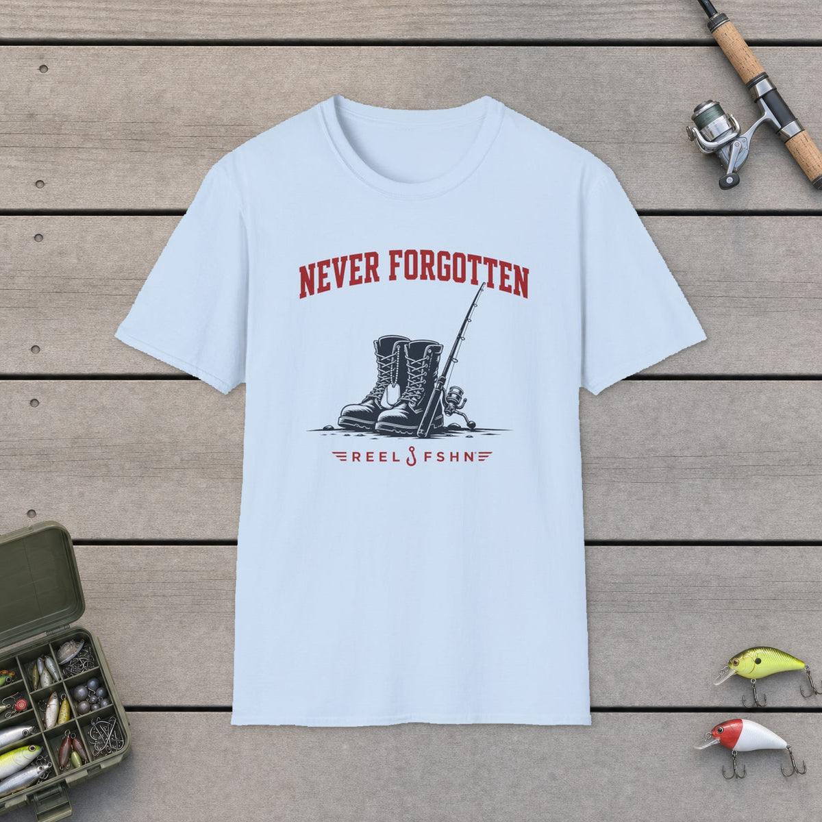 Never Forgotten T-Shirt on a wooden dock with fishing rod, reel, tackle box and lures