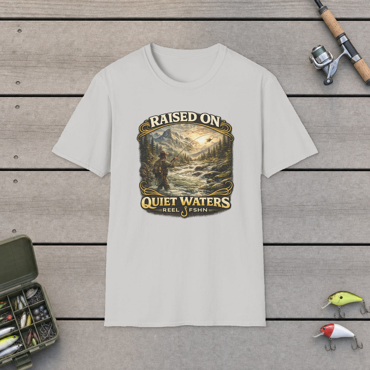 Raised On Quiet Waters T-Shirt on a wooden dock with fishing rod, reel, tackle box and lures