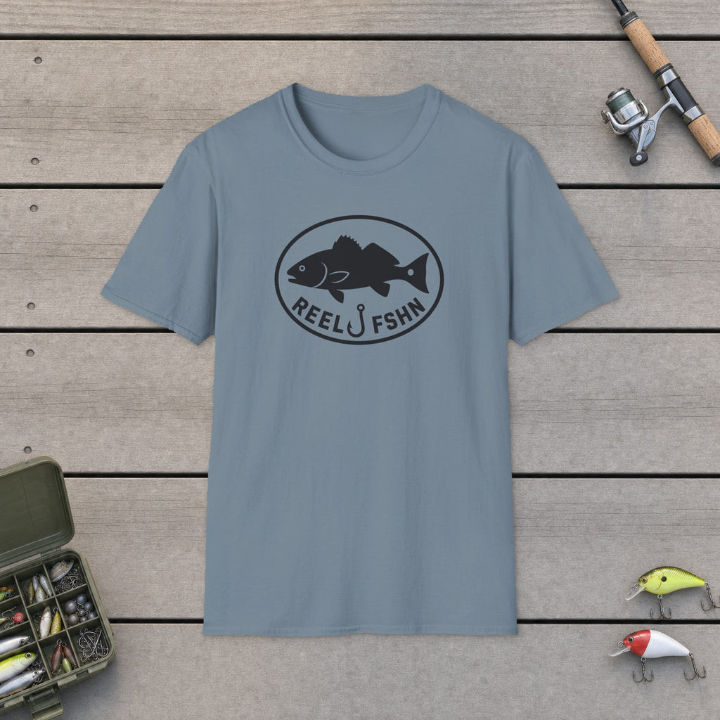 Redfish Oval Badge T-Shirt on a wooden dock with fishing rod, reel, tackle box and lures