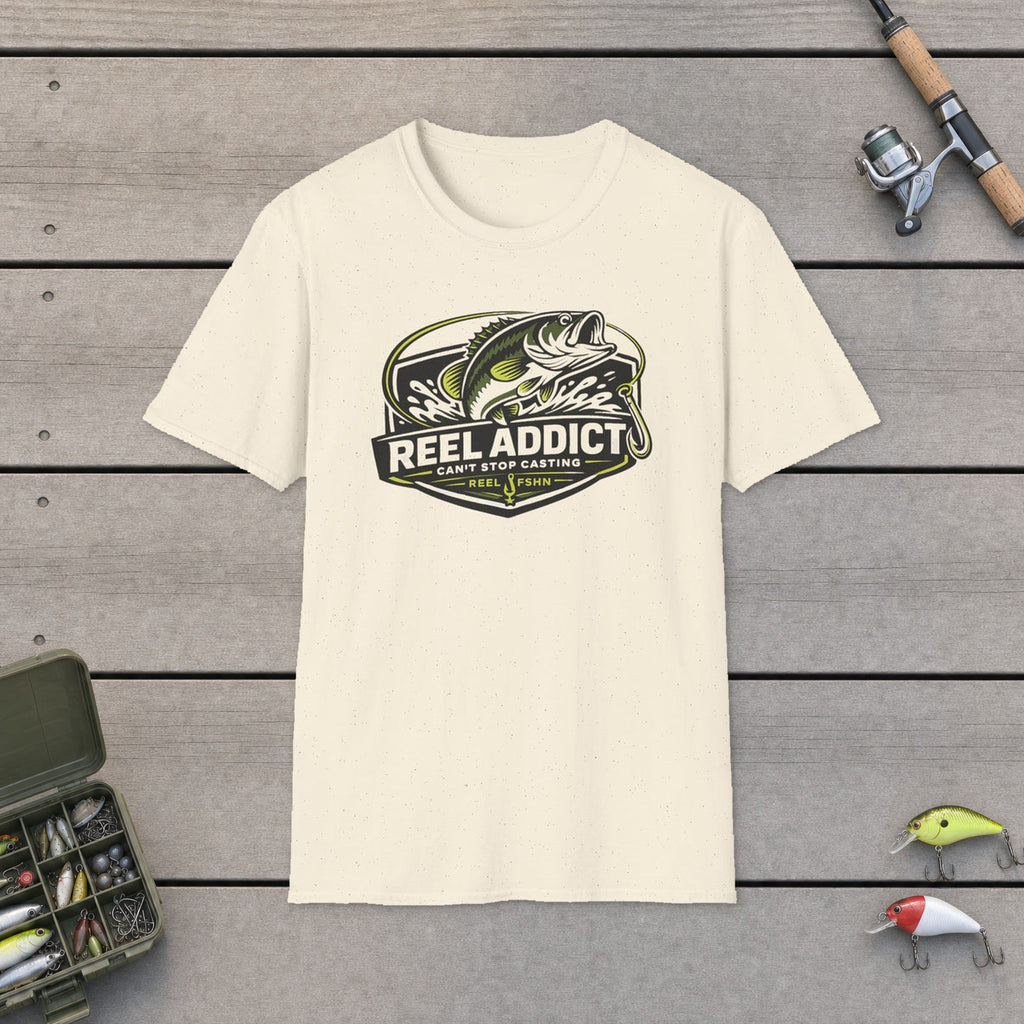 Reel Addict Can't Stop Casting T-Shirt flat-laid on wooden dock boards beside a fishing rod and tackle box