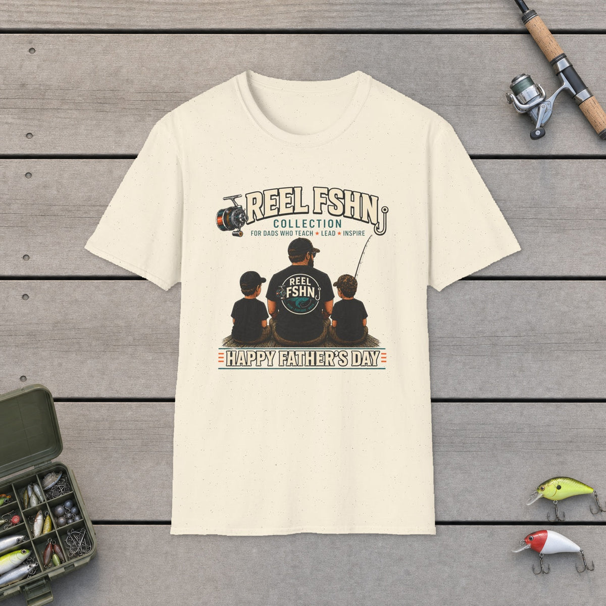 REEL FSHN Happy Father's Day T-Shirt on a wooden dock with fishing rod, reel, tackle box and lures