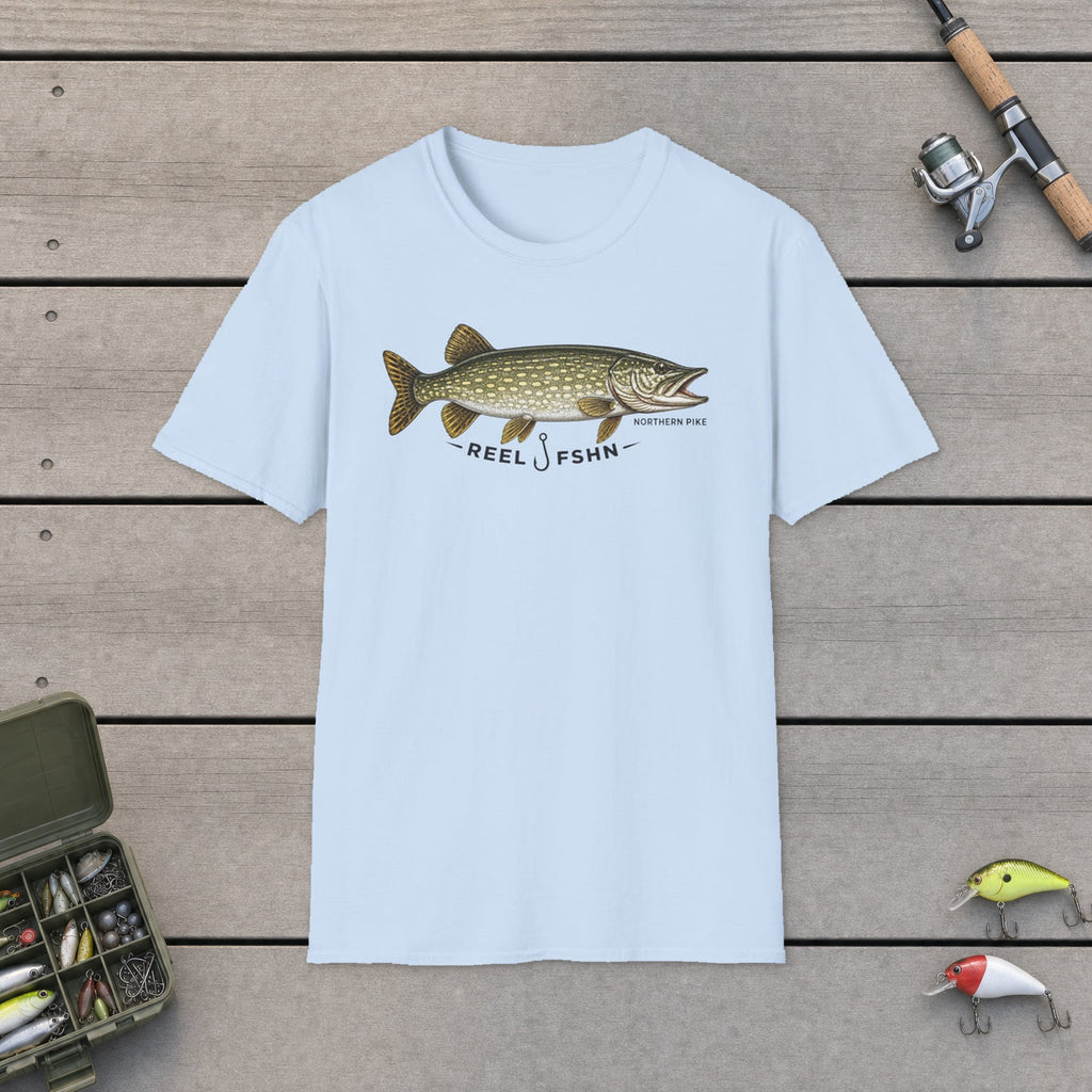 REEL FSHN NORTHERN PIKE T-Shirt flat-laid on wooden dock boards beside a fishing rod and tackle box
