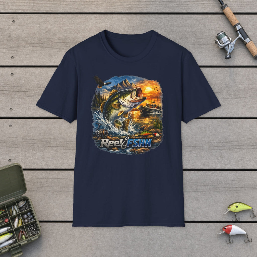 REEL FSHN T-Shirt flat-laid on wooden dock boards beside a fishing rod and tackle box