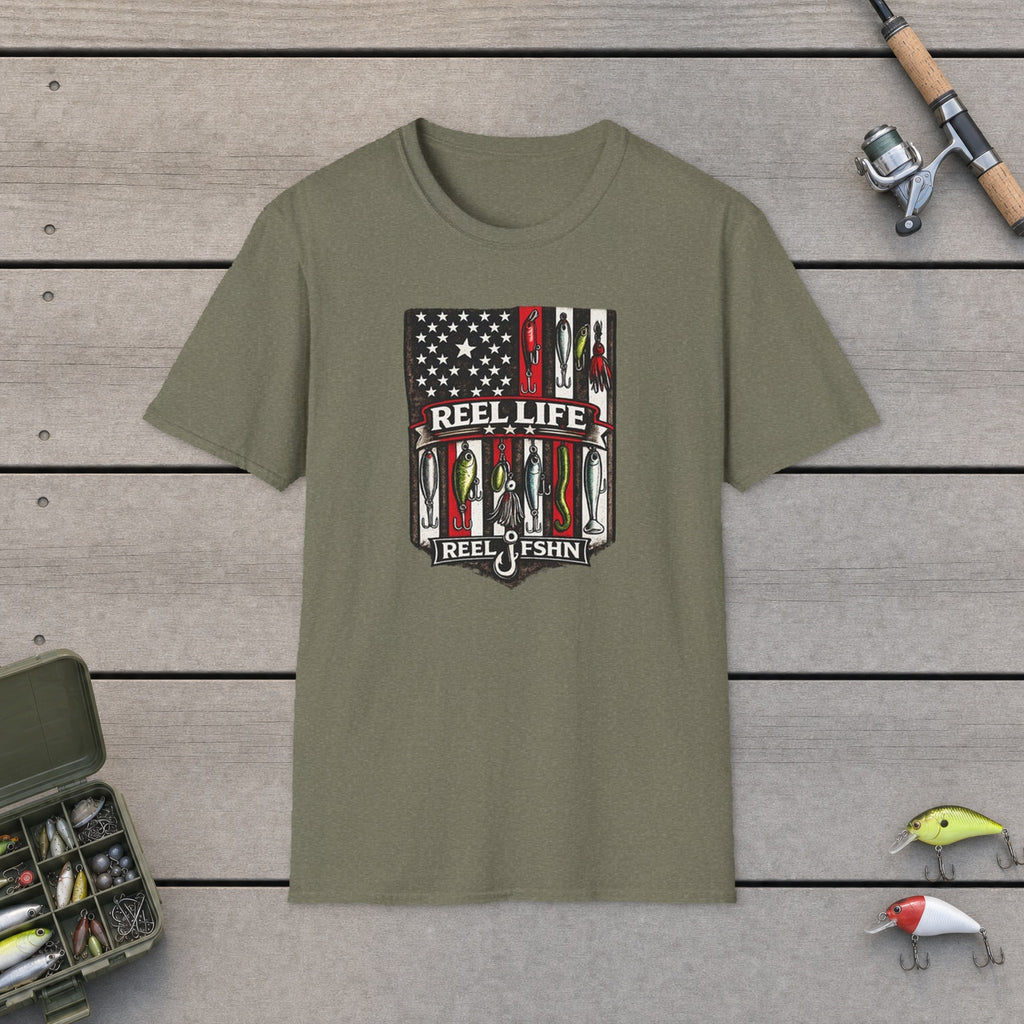 REEL Life! T-Shirt flat-laid on wooden dock boards beside a fishing rod and tackle box