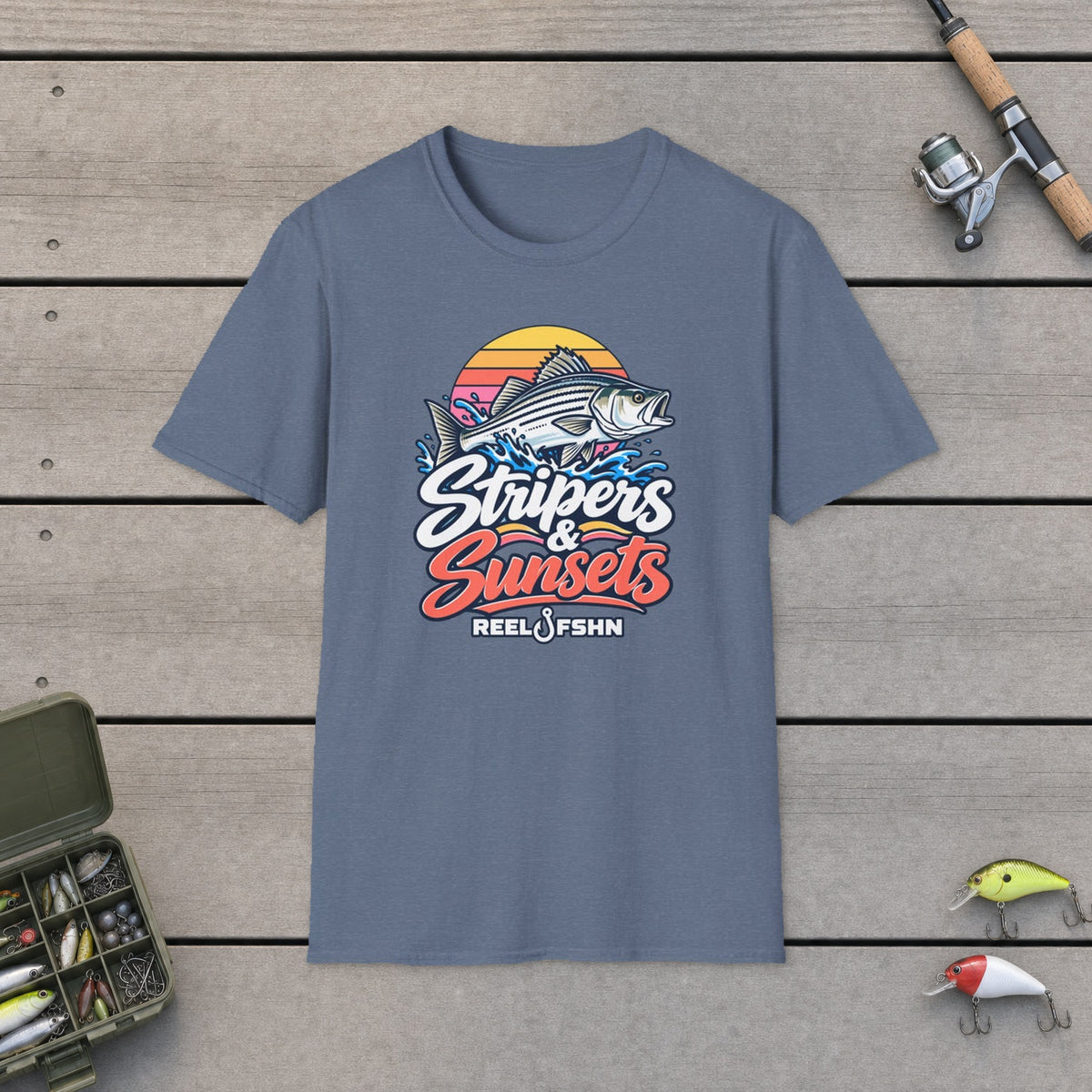 Stripers & Sunsets T-Shirt on a wooden dock with fishing rod, reel, tackle box and lures