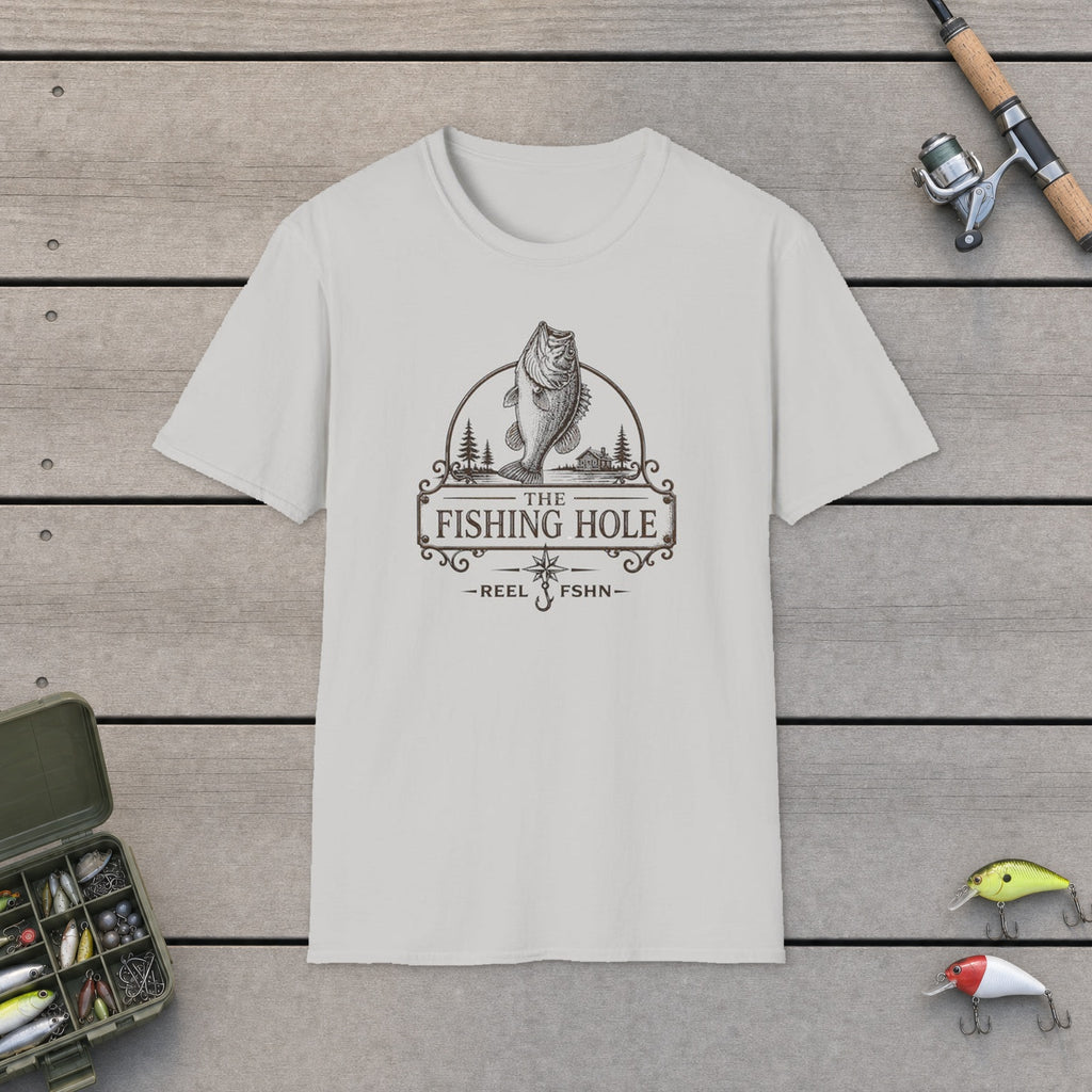 The Fishing Hole T-Shirt flat-laid on wooden dock boards beside a fishing rod and tackle box