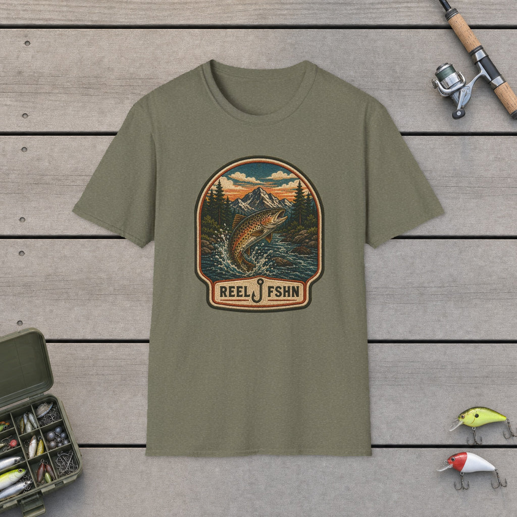 Trout Stream Patch T-Shirt flat-laid on wooden dock boards beside a fishing rod and tackle box