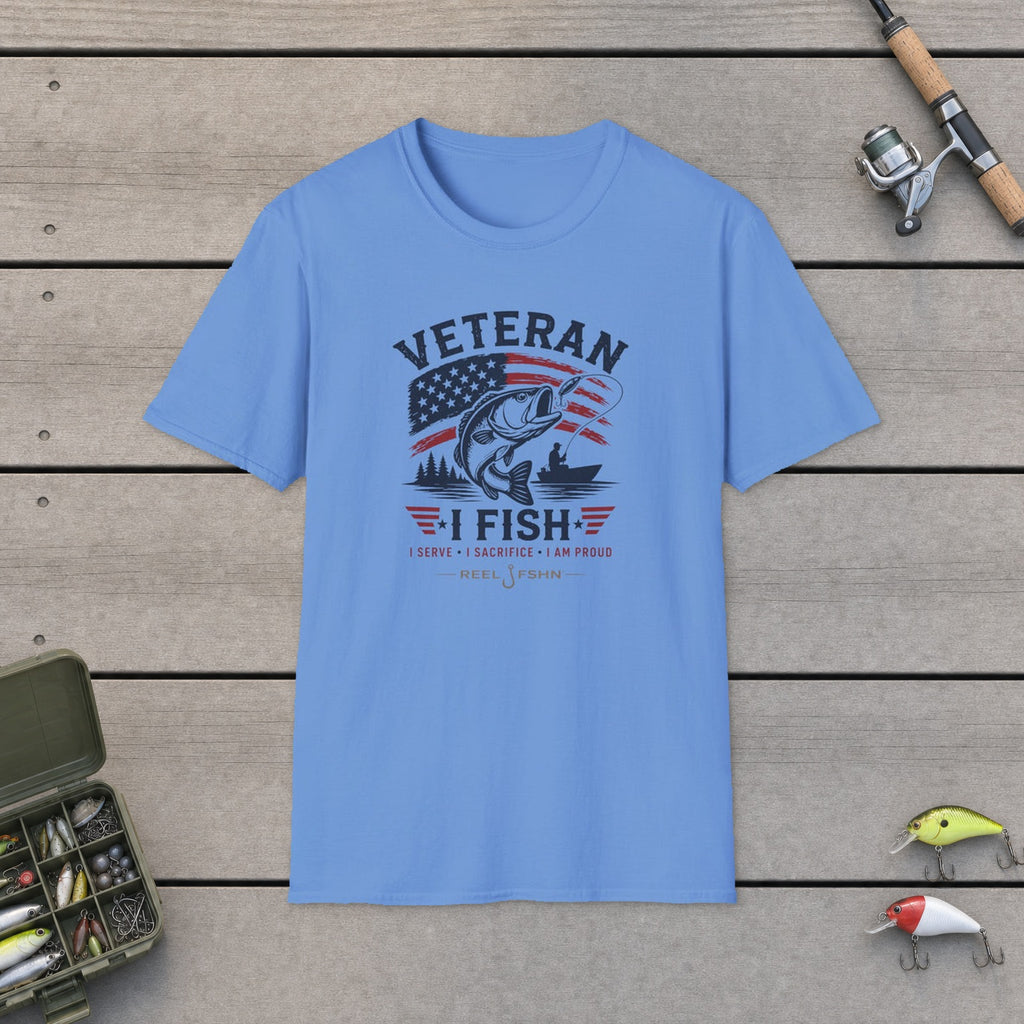 Veteran I Fish I Serve I Sacrifice I Am Proud T-Shirt flat-laid on wooden dock boards beside a fishing rod and tackle box