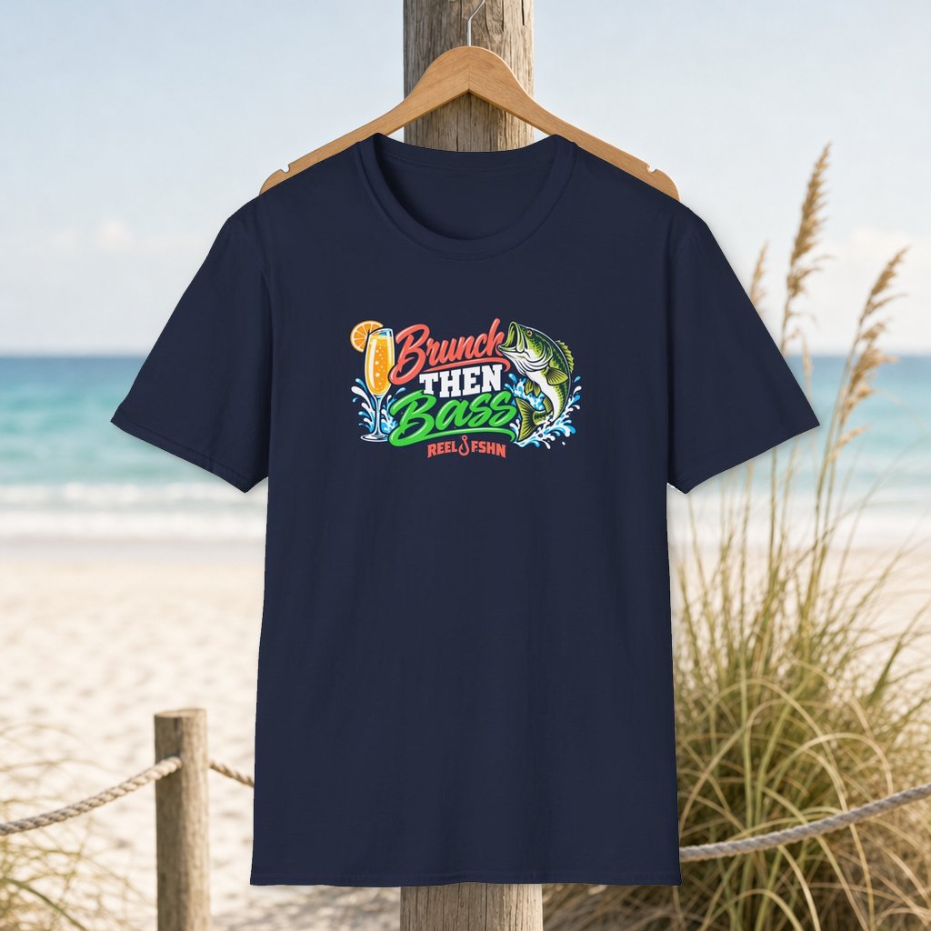 Brunch Then Bass T-Shirt on a hanger beside a sandy beach and turquoise coastal water