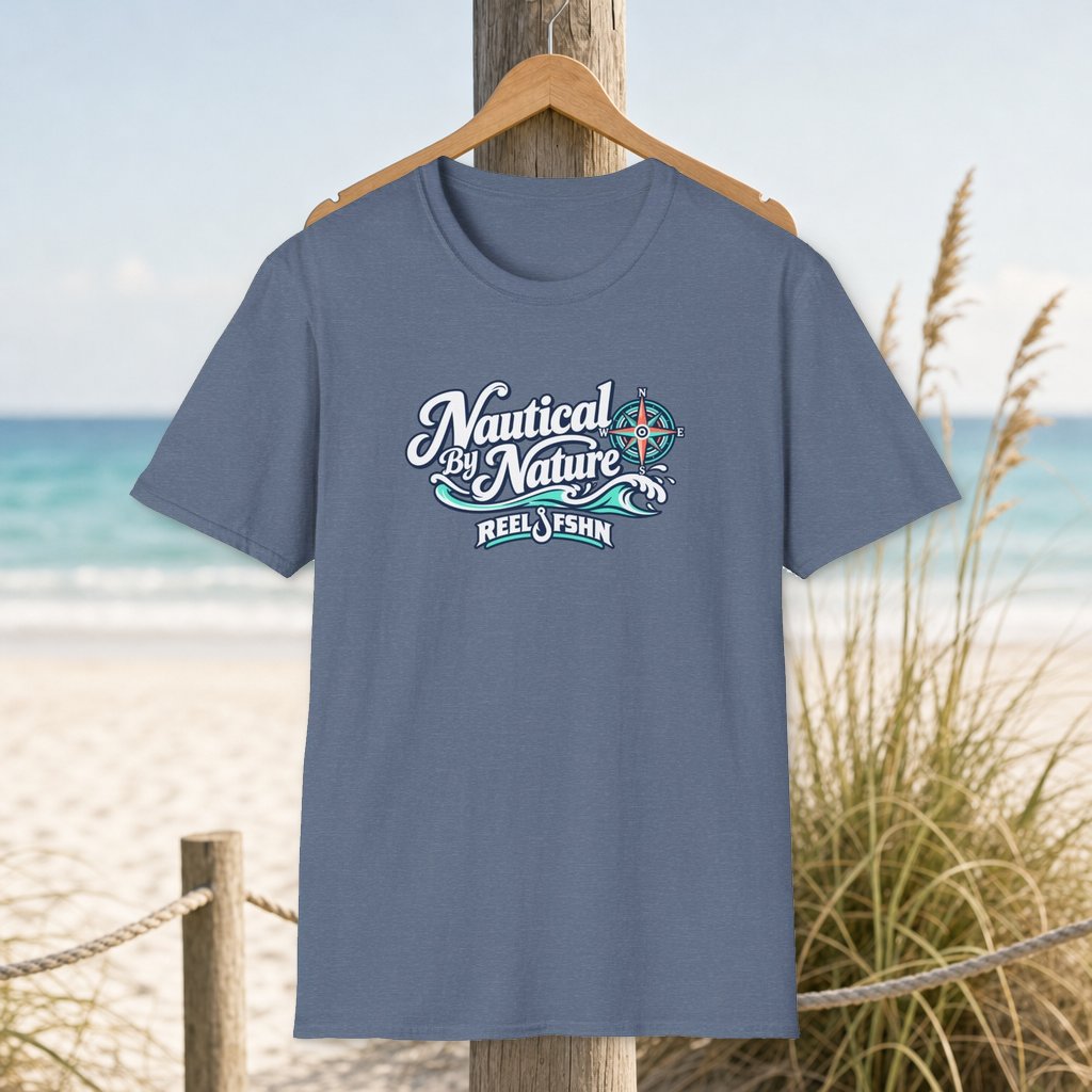 Nautical By Nature T-Shirt on a hanger beside a sandy beach and turquoise coastal water
