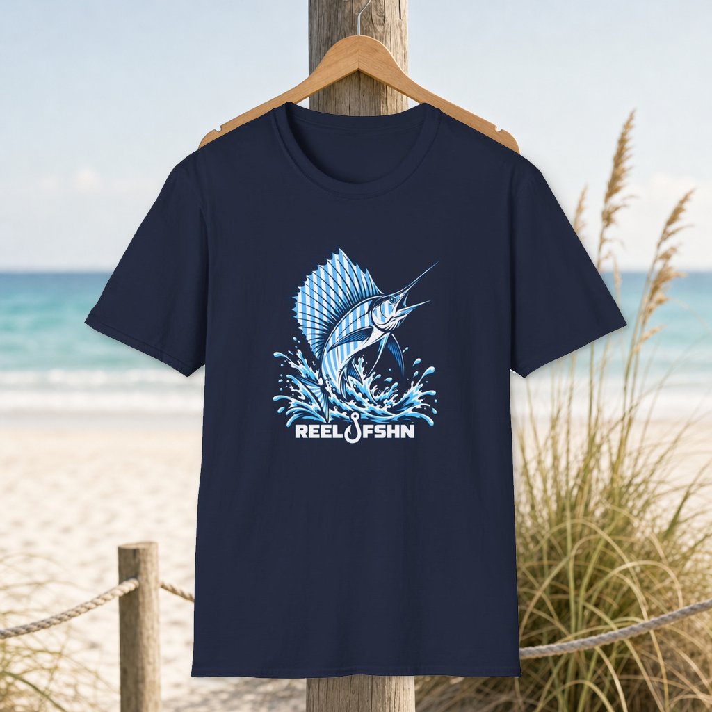 Blue & White Marlin T-Shirt on a hanger beside a sandy beach and turquoise coastal water